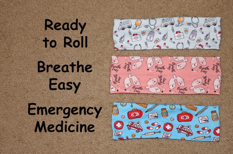 May include: Three headbands with different medical-themed prints. The top headband is light blue with a white ambulance, stethoscope, pills, and other medical symbols. The middle headband is pink with white lungs and the text "Breathe Easy". The bottom headband is light blue with a white ambulance, pills, and a red cross.