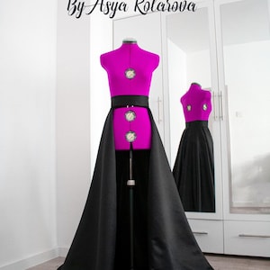May include: A black satin overskirt with a black waistband, worn over a fuchsia-colored dress form. The text "Made To Measure By Asya Kolarova" is visible at the top of the image.