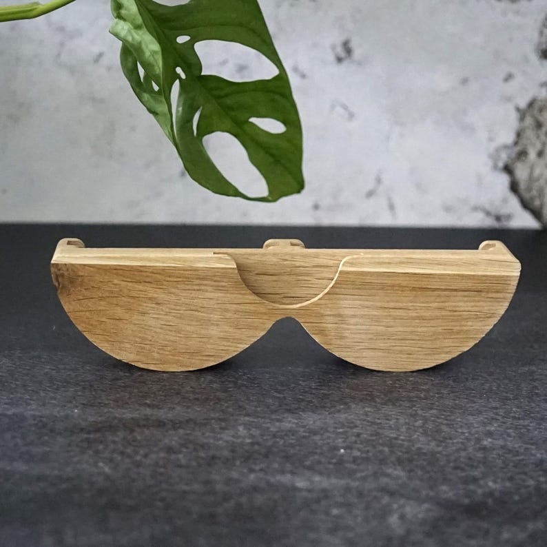 May include: A wooden, semi-circular shelf with a curved design. The shelf is made of light-colored wood and has a natural finish. The shelf is designed to hold small items and has a unique, modern look.