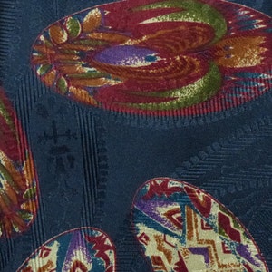 May include: A dark blue fabric with a repeating pattern of colorful, abstract oval shapes. The ovals are filled with a variety of colors, including red, orange, yellow, green, blue, and purple.