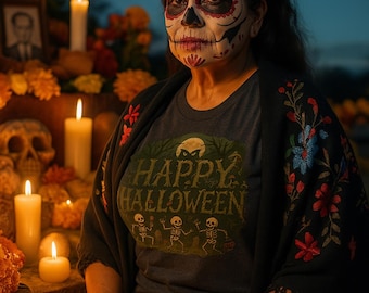 May include: A person with Day of the Dead face paint and a red rose crown. They wear a gray t-shirt with "Happy Halloween" and skeleton graphics. A black shawl with floral embroidery is draped over their shoulders. Lit candles and orange flowers are in the background.