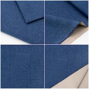 May include: Close-up of a dark blue denim fabric with a textured weave. The fabric is folded over to show the underside, which is a light beige colour.