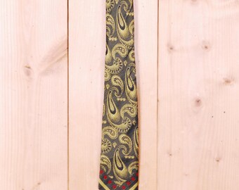 May include: A dark green paisley patterned tie with gold accents and a red and white trim.