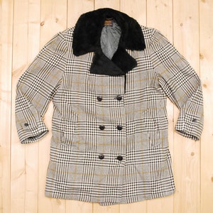 May include: A black and white checked coat with a black faux fur collar. The coat has a double breasted closure with four buttons.
