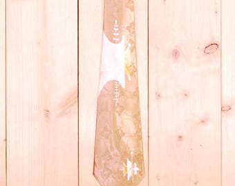 May include: A vintage necktie with a beige background and a repeating floral pattern. The tie features white geometric shapes and a stylized emblem near the tip. The tie is made of a shiny fabric.