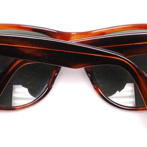 Puede incluir: Un par de gafas de sol Ray-Ban de carey marr&oacute;n con lentes verdes. Las gafas est&aacute;n dobladas por la mitad y el logotipo de Ray-Ban es visible en la patilla derecha.