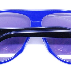 Puede incluir: Gafas de sol aviador azules con brazos negros y la marca Carrera en ambos lados.