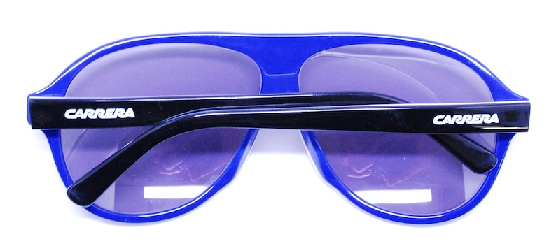 Puede incluir: Gafas de sol aviador azules con brazos negros y la marca Carrera en ambos lados.