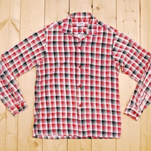 Könnte beinhalten: Ein langärmliges Hemd mit rotem, schwarzem und weißem Karomuster und einem Knopfkrag.