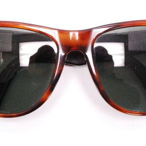 Puede incluir: Gafas de sol de carey con lentes verde oscuro. Las gafas tienen un estilo aviador cl&aacute;sico.