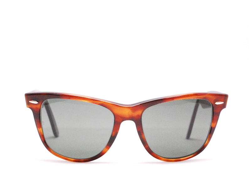 Puede incluir: Gafas de sol de carey con lentes grises oscuras. Las gafas tienen un estilo cl&aacute;sico y retro.