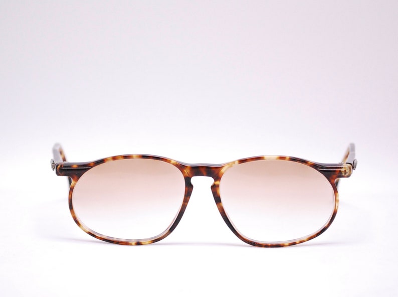 May include: Tortoiseshell framed sunglasses with brown gradient lenses.
