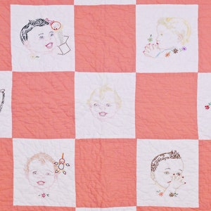 May include: A pink and white patchwork quilt with embroidered images of babies. Each square features a different baby with a unique expression and detail. The quilt is a charming and nostalgic piece of textile art.