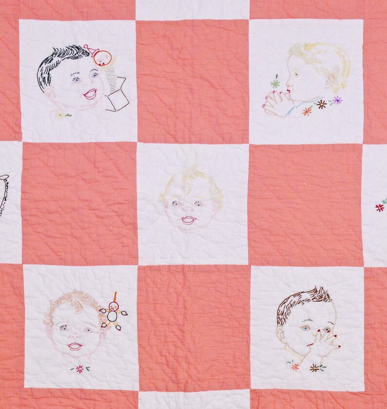 May include: A pink and white patchwork quilt with embroidered images of babies. Each square features a different baby with a unique expression and detail. The quilt is a charming and nostalgic piece of textile art.