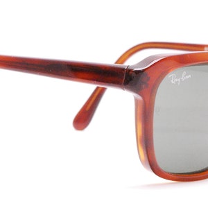 May include: Brown tortoise shell Ray-Ban sunglasses with green lenses.