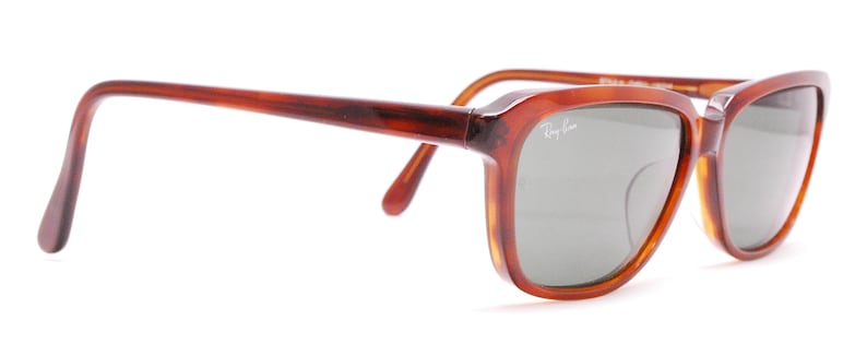 May include: Brown tortoise shell Ray-Ban sunglasses with green lenses.