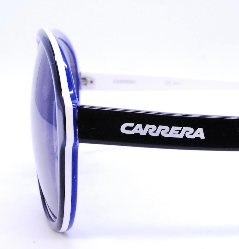 Puede incluir: Gafas de sol con montura azul y blanca, con brazos negros y la palabra "CARRERA" en letras blancas en los brazos.