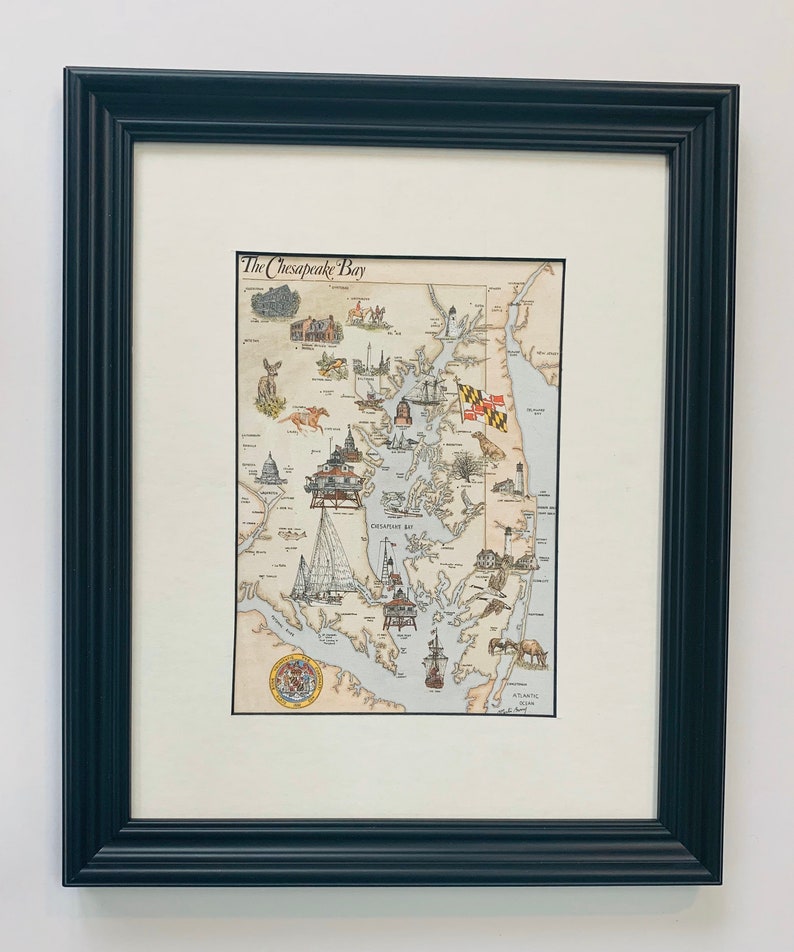 May include: A framed illustration of the Chesapeake Bay, Maryland, with a detailed map of the bay and surrounding areas. The illustration includes various landmarks, including the Chesapeake Bay Bridge, the US Naval Academy, and the Baltimore Inner Harbor. The title "The Chesapeake Bay" is written at the top of the illustration.
