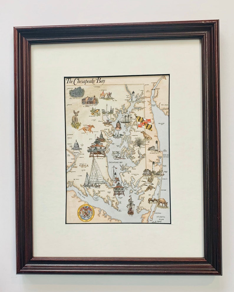 May include: A framed illustration of the Chesapeake Bay, Maryland, with a detailed map of the bay and surrounding areas. The illustration features various landmarks, including lighthouses, ships, and buildings. The title "The Chesapeake Bay" is printed at the top of the map.