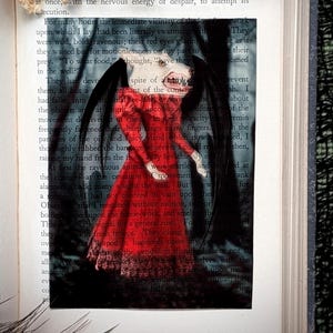 May include: A gothic-themed image featuring a red-dressed figure with bat wings, set against a backdrop of an open book. The figure has a pale face and dark hair. Dried flowers are at the top.