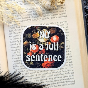 Op de afbeelding: Een sticker met een zwarte achtergrond en een kleurrijk bloemenontwerp. De tekst "NO" staat in witte letters en de tekst "is a full sentence" staat in witte letters met een zwarte omtrek.
