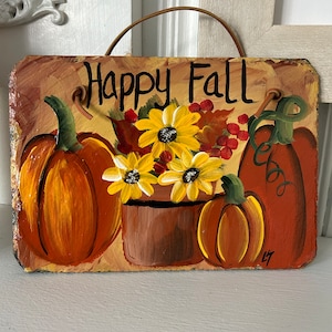 May include: Hand-painted rectangular sign with the words "Happy Fall" in black script. The sign features orange pumpkins, yellow sunflowers, and red berries. A brown leather strap is attached for hanging.
