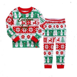 May include: Red and green Christmas pajamas with a white background. The top has a snowflake and reindeer pattern and the text "Custom Text". The pants have a snowman and candy cane pattern.