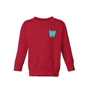 May include: Red long-sleeved sweatshirt with a turquoise letter W on the front.