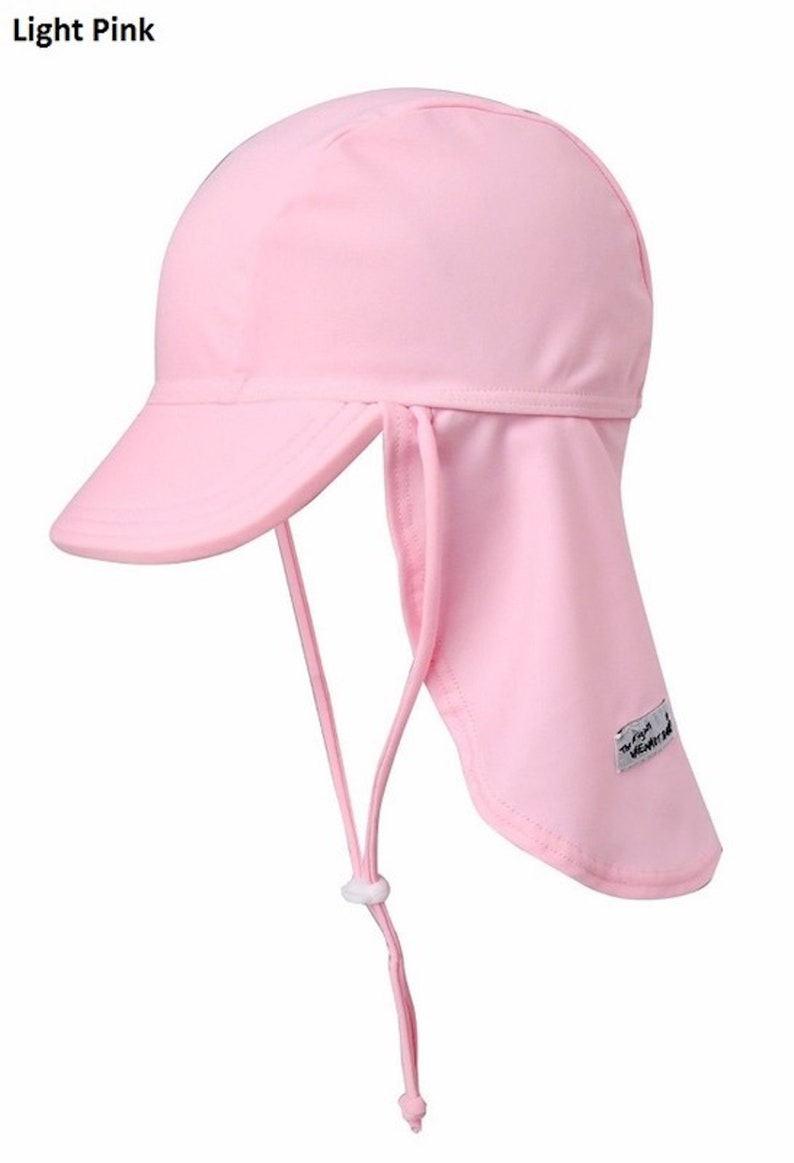 May include: A light pink sun hat with a long flap that can be tied at the back of the neck. The hat has a small brim and a white label with the text "Sun Vent".