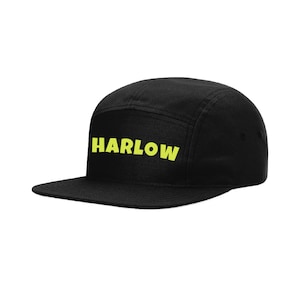 May include: Black 5-panel cap with a yellow "HARLOW" logo.