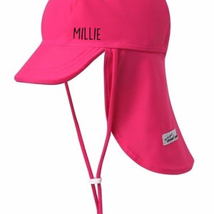 May include: Hot pink sun hat with a long flap in the back to protect the neck. The hat has a brim and a chin strap. The hat says "MILLIE" on the front.