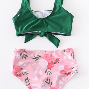 May include: A green bikini top with a tie front and a pink floral print bikini bottom.