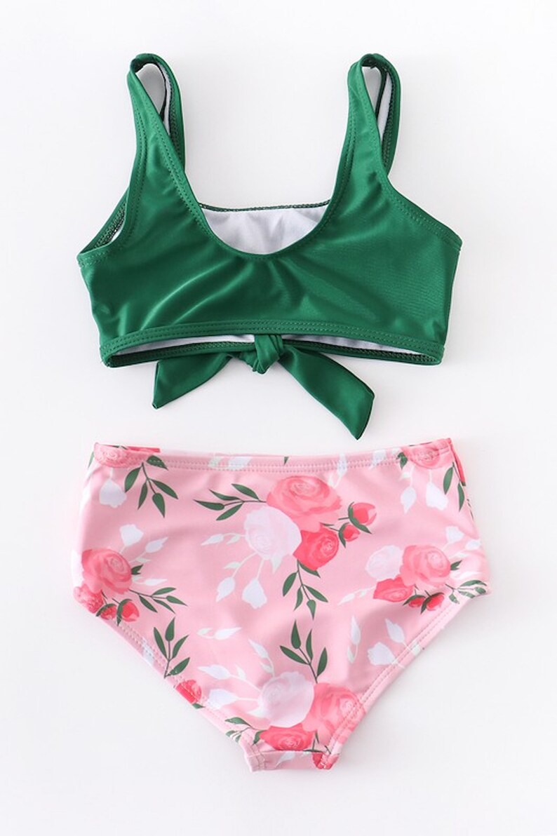 May include: A green bikini top with a tie front and a pink floral print bikini bottom.