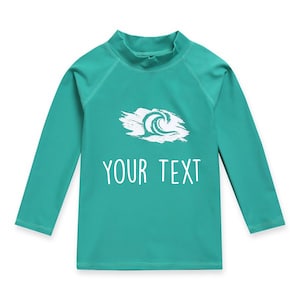 May include: A turquoise long-sleeved rash guard with a white wave graphic and the text "YOUR TEXT" printed on the front.