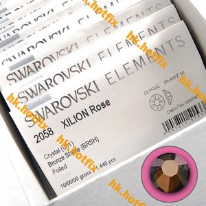 Puede incluir: Primer plano de un pequeño cristal facetado transparente con un tono bronce. El cristal está etiquetado como "XILION Rose" y forma parte de un paquete de 1.440 piezas de Swarovski Elements.
