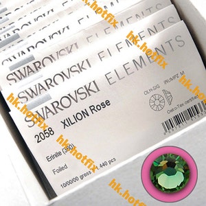 May include: A close-up of a package of Swarovski Xilion Rose Erinite (360) foiled crystals. The package is white with black text and a barcode. The crystals are green and have a foiled finish. The package is labeled "2058" and "10/00/00 gross 1,440 pcs".