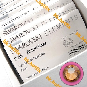 Może przedstawiać: Zbliżenie na opakowanie kryształów Swarovski Xilion Rose 2058 Light Colorado Topaz. Opakowanie jest białe z czarnym tekstem i kodem kreskowym. Kryształy są sprzedawane w opakowaniach po 1440 sztuk i posiadają certyfikat Oeko-Tex.