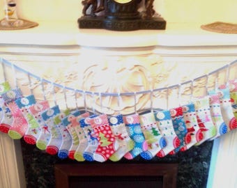 May include: A holiday advent calendar garland featuring twenty-four miniature fabric stockings hanging from a light blue ribbon. Each stocking displays a unique colorful pattern, including Christmas trees, snowflakes, and dots, with numbered tags.