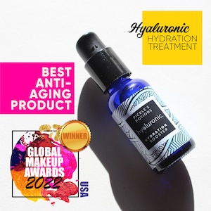 May include: A blue glass bottle with a black dropper top and a white label that says "Pickle's Potions hyaluronic. Hydration Booster". The bottle is a winner of the Global Makeup Awards 2022 for Best Anti-Aging Product.