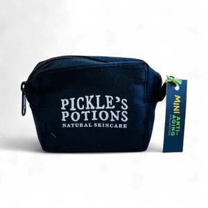 May include: A navy blue canvas cosmetic bag with a black zipper and the text "PICKLE'S POTIONS NATURAL SKINCARE" in white. A small tag reads "MINI ANTI-AGING COLLECTION".