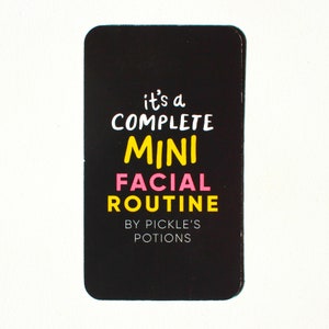 Op de afbeelding: Zwarte kaart met witte tekst die "it's a complete mini facial routine by pickle's potions" luidt. De woorden "mini" en "facial" zijn in roze en geel.