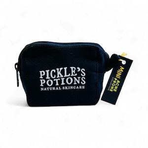 May include: A small, black cosmetic bag with a zipper closure. The bag features the text "PICKLE'S POTIONS NATURAL SKINCARE" in white. A small tag attached reads "MINI ACNE PRONE COLLECTION".