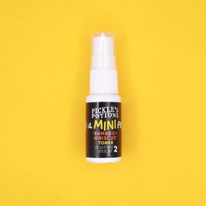 May include: A small white bottle with a black label that says "Pickle's Potions" and "It's a Mini Potion" with a smaller label that says "'Bamboo + Hibiscus' Toner routine stage 2".