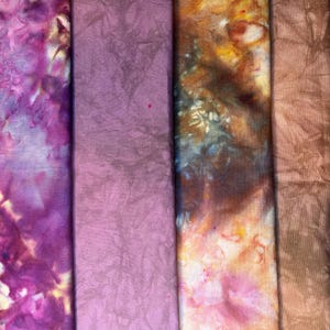 May include: Five fabric swatches in various shades of purple, brown, and orange with tie-dye patterns.
