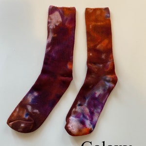 May include: A pair of tie-dye socks in shades of purple, orange, and brown. The socks have a galaxy-like pattern and are labeled "Galaxy".