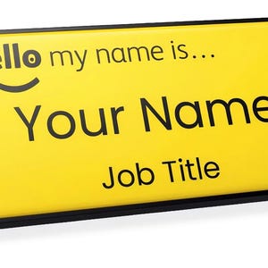 May include: A rectangular yellow name badge with a black trim. The text on the badge reads "# hello my name is..." above "Your Name" and "Job Title" in black. A smiling face graphic is above the words "Your Name".