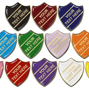 May include: Twelve shield-shaped badges in various colors with gold trim. Each badge has the text "YOUR TEXT HERE" printed on it.