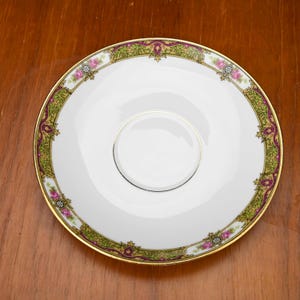 Puede incluir: Un letrero de madera hecho a mano con el texto "Welcome to our home" en un estilo manuscrito. El letrero está pintado de blanco con un marco teñido oscuro. Una pequeña planta verde está colocada encima.