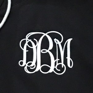 May include: Black hoodie with a white monogram of the letters "DBM" in a cursive font.