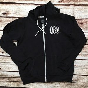 May include: Black zip-up hoodie with a white monogram "DBM" on the front.
